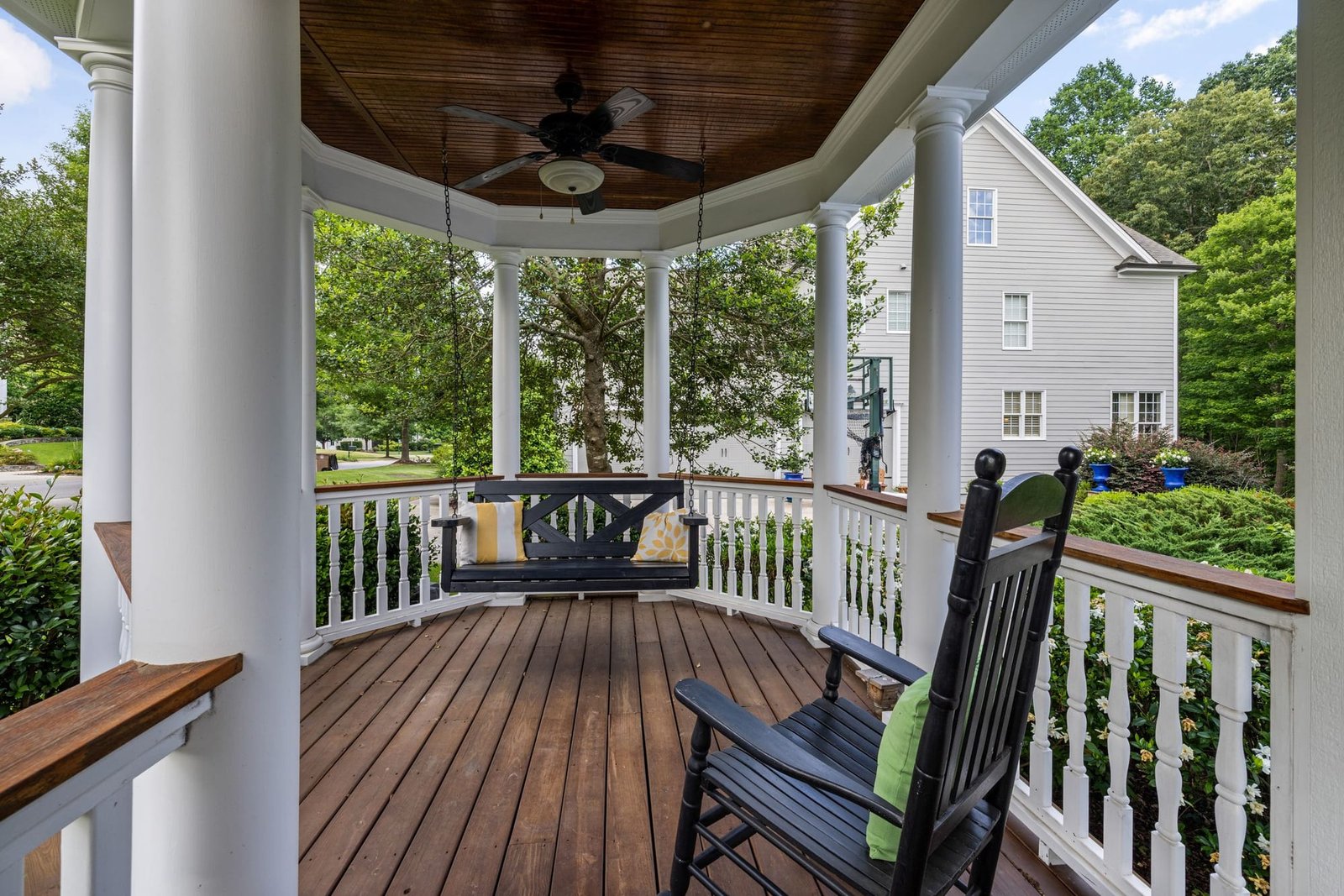 The wraparound porch with a swing and a rocking chair