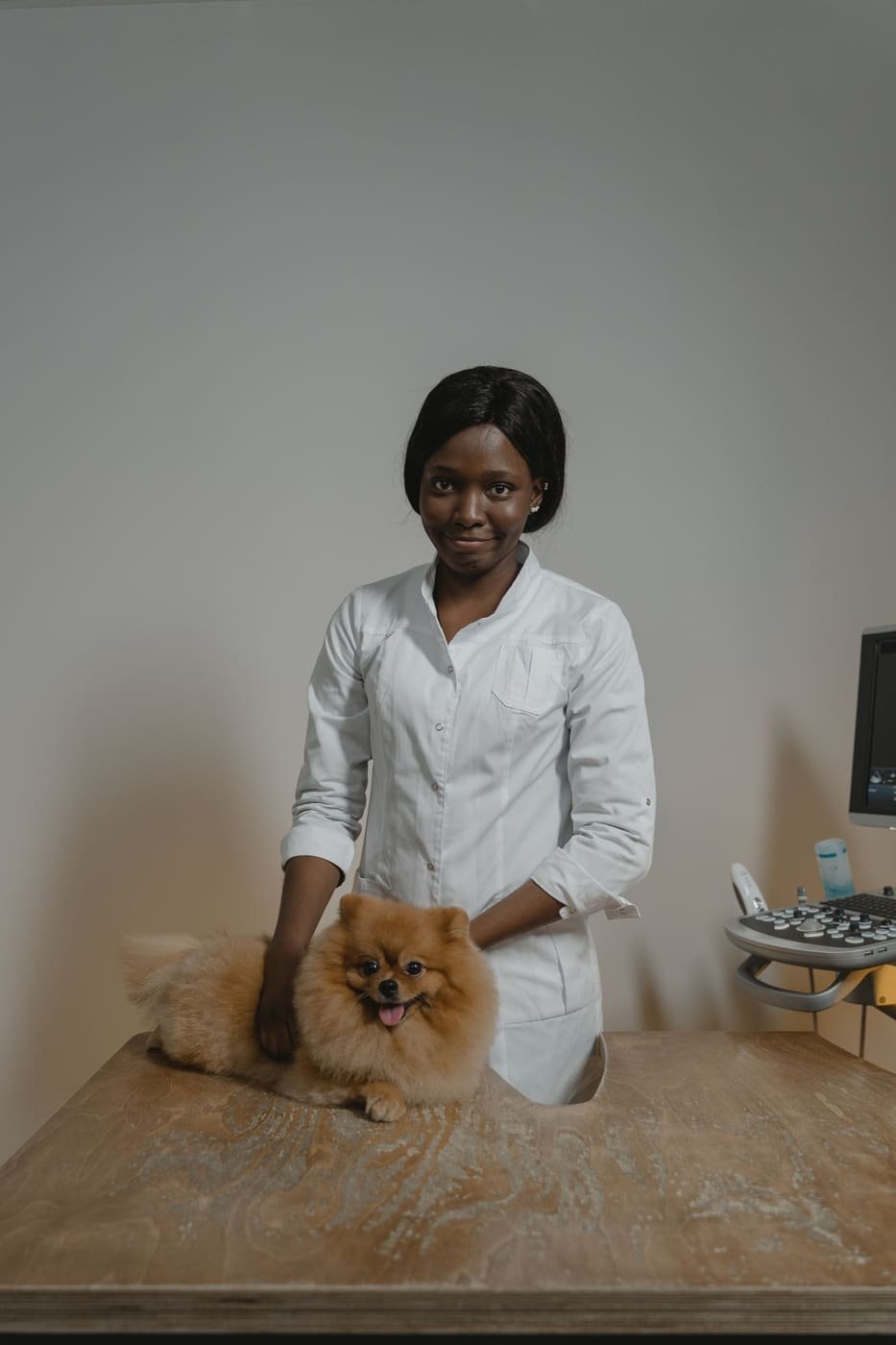 Dr. Grace Okafor in a white coat beside the exam table