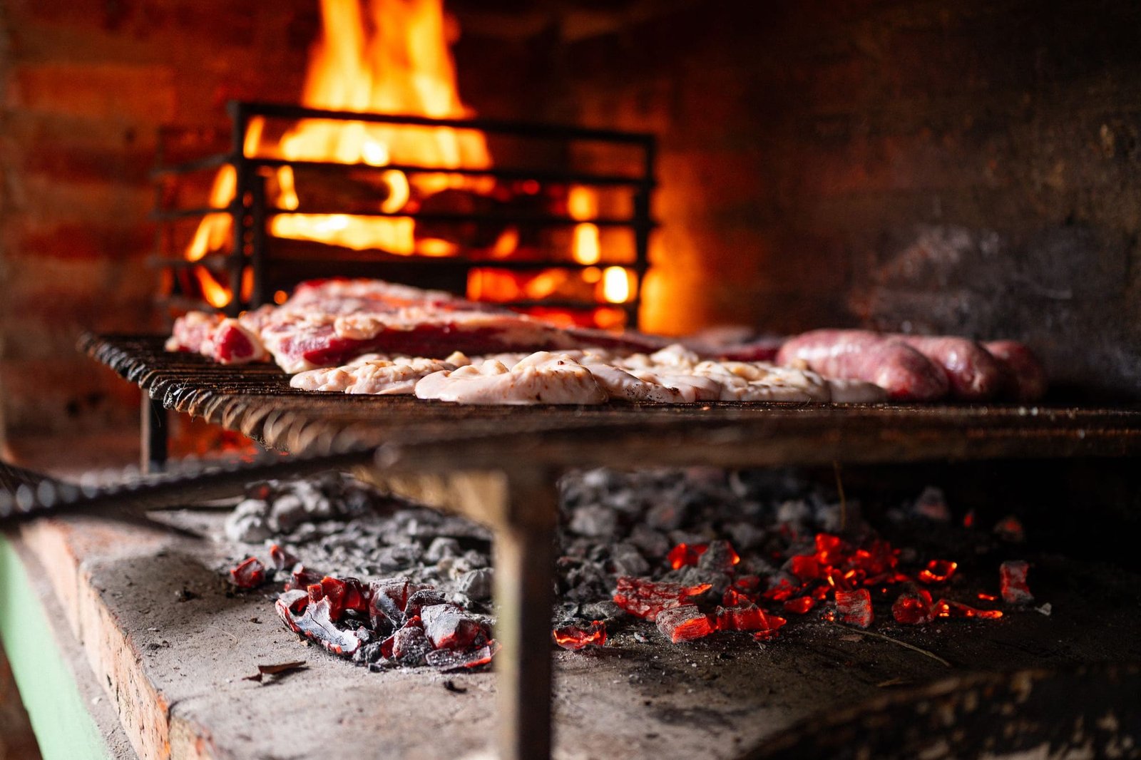 Steaks and chorizo on the grill under the wood fire at Casa Lumbre