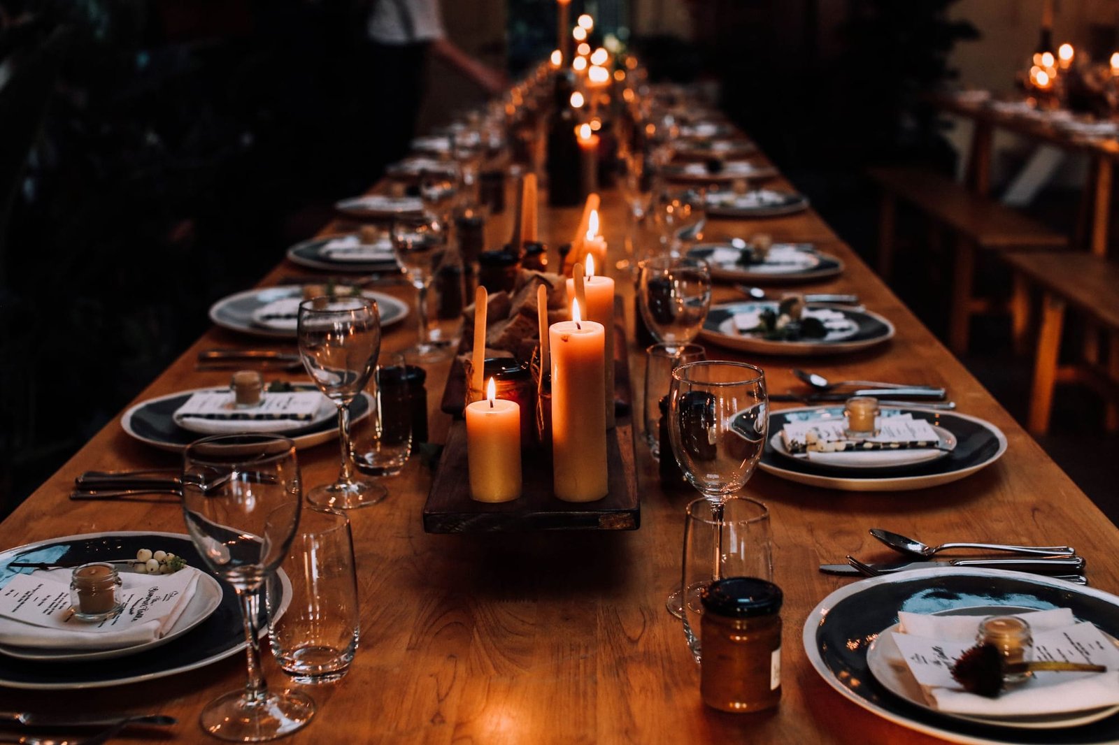 The long candlelit table in the back room, set for a dinner