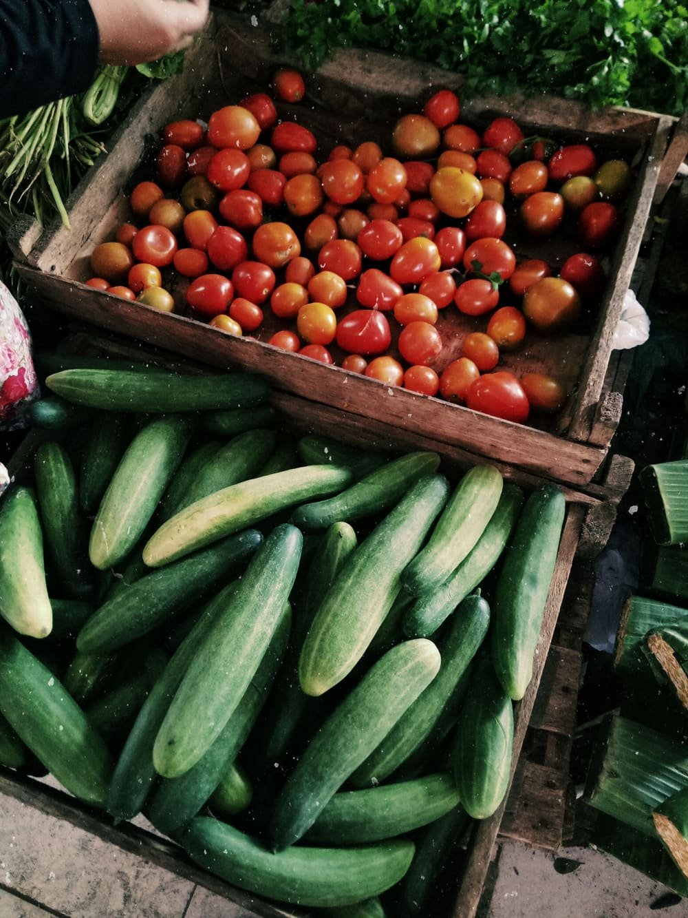 Wooden crates of cucumbers and tomatoes