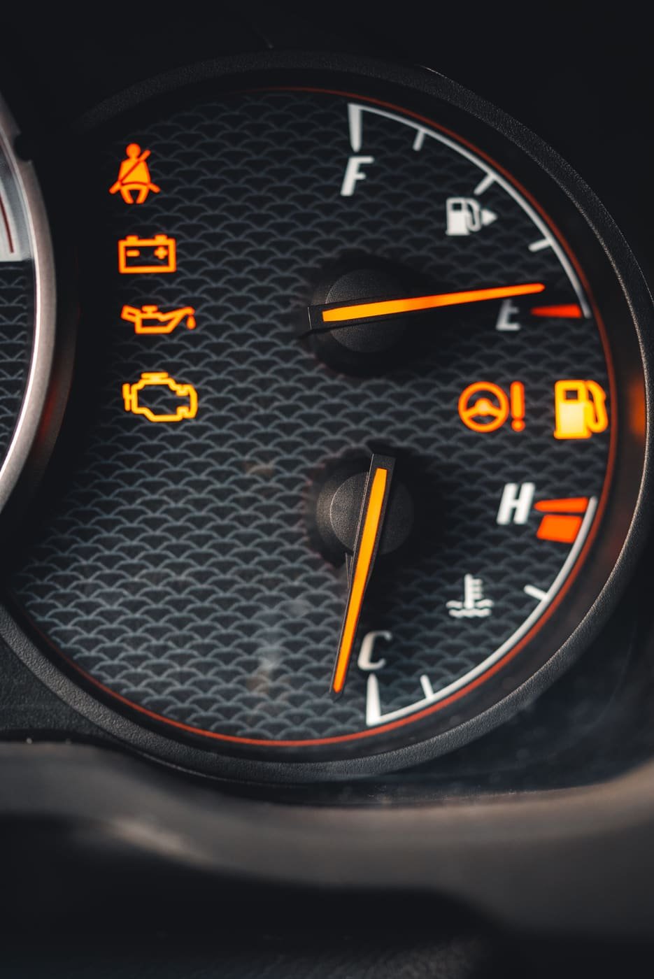 Dashboard gauges with the orange check engine light on