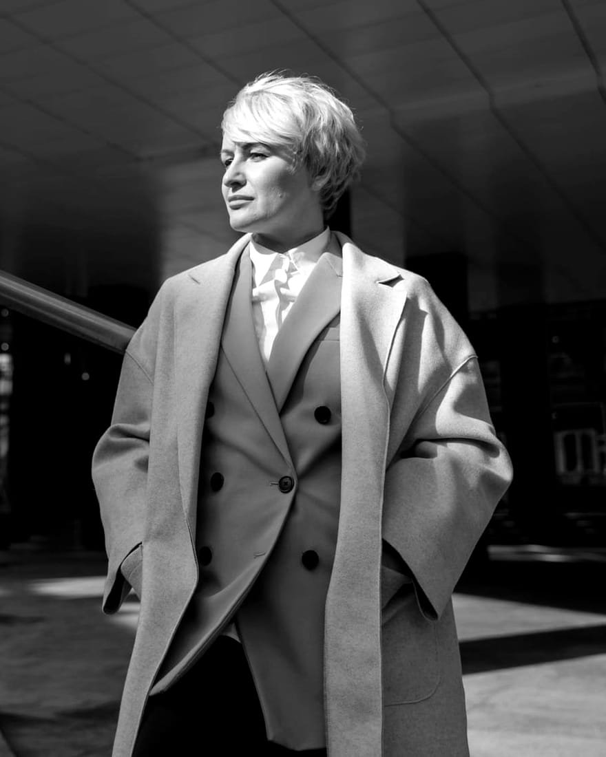 Ruth Harlan in a light overcoat
