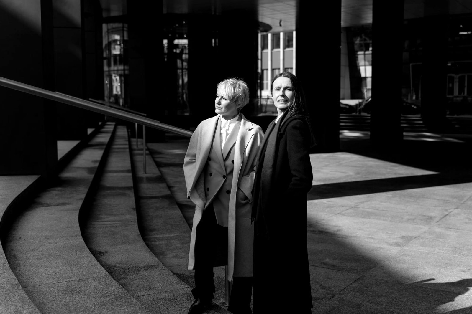 Ruth Harlan and Elena Reyes standing on the curved steps outside their office