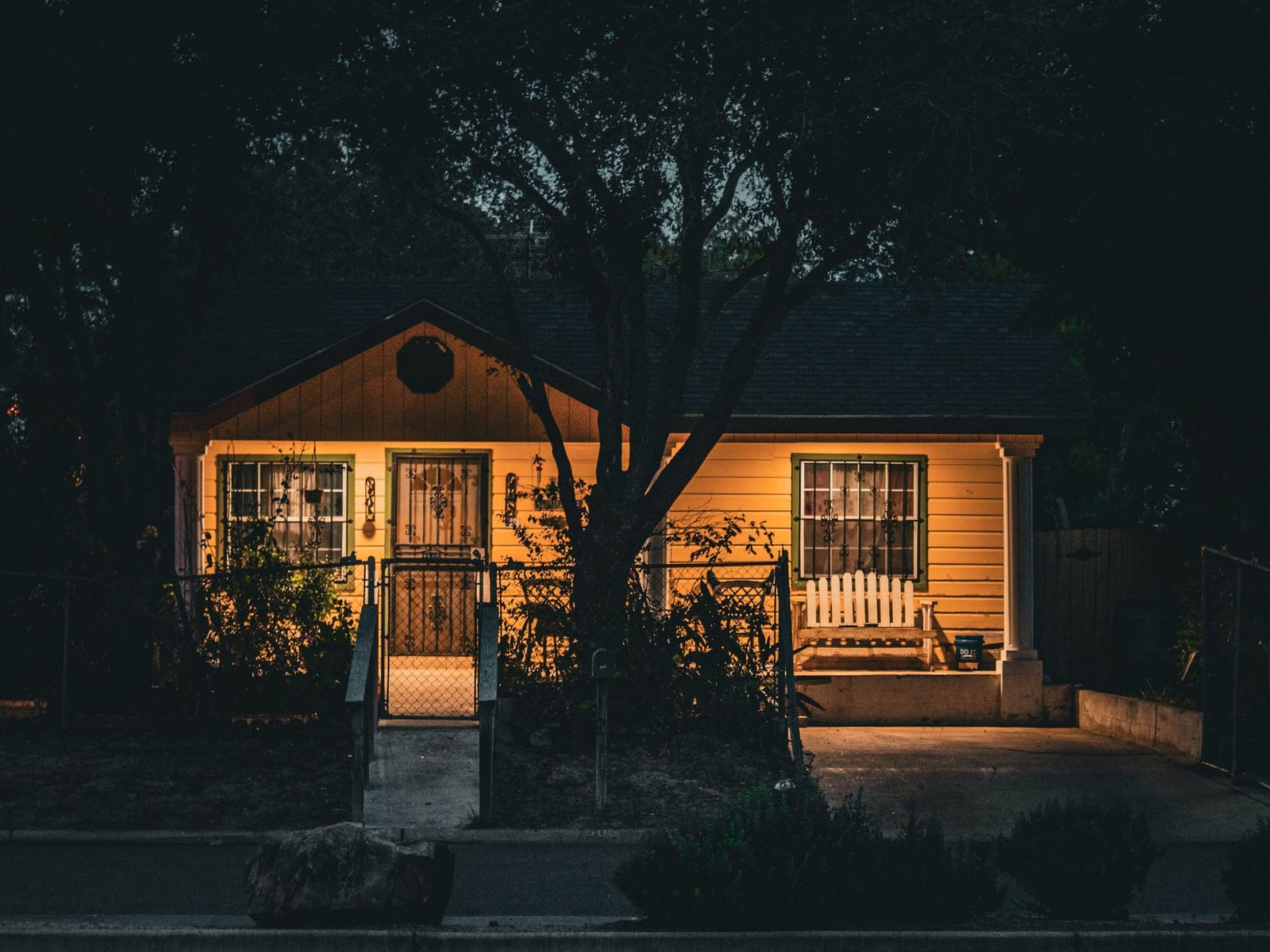 A small house at night with its porch light on
