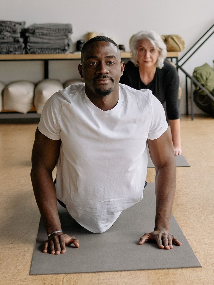 Marcus Bell in a cobra pose looking toward the class