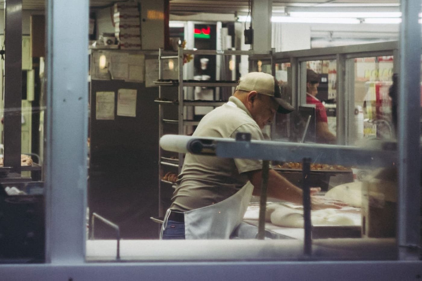 A baker working in the lit kitchen before dawn
