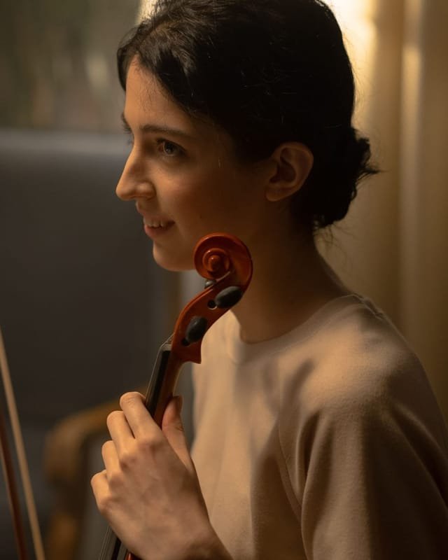 Clara Novak holding her violin and bow